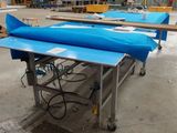 un grand bateau bleu posé sur une table dans un entrepôt