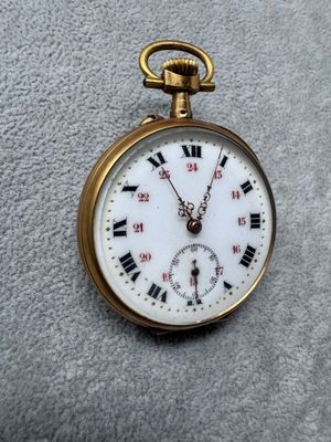 une montre de poche en or avec des chiffres romains