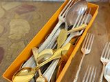 a box of silverware sitting on a table with forks and spoons