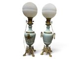 une paire de lampes blanches et dorées, chacune dotée d'un abat-jour en verre
