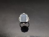 a close up of a ring with a stone in it on a table