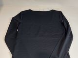 the back of a black shirt with long sleeves on a white surface