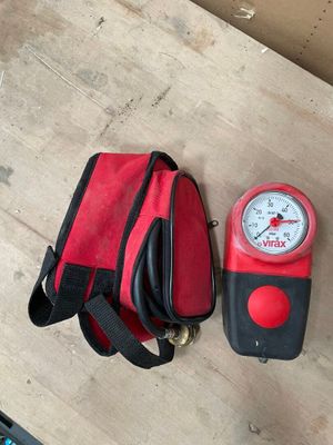 un sac rouge et noir et un compteur rouge et noir posés sur une table en bois