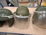three helmets sitting on top of a wooden table in a room