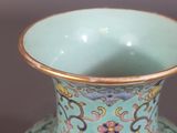 a blue vase with a gold rim sitting on a table