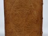 an old brown book with a decorative design on it