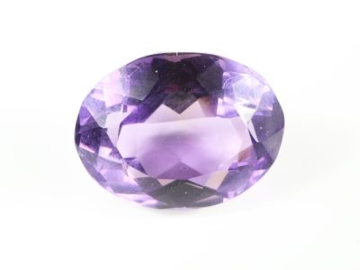 un gros plan d'une pierre d'améthorate violette posée sur une surface blanche