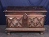 an old wooden chest sitting on top of a floor next to a blue backdrop