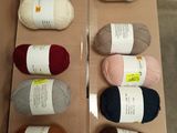 several balls of yarn are in a box on a table