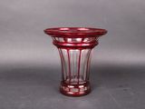a red glass vase sitting on a gray surface