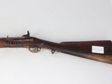 an old rifle with a wooden barrel and brass fittings