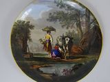 une assiette sur laquelle est représentée une femme et deux vaches