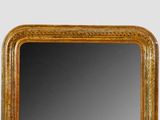 a mirror that has a gold frame on it
