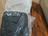 a white toilet in a box with a plastic cover