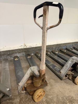 a dolly with a handle on it next to a pile of pallets