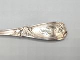 a silver spoon with a dollar sign on it sitting on a table