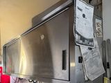 a stainless steel oven in a kitchen with a lot of papers on the wall
