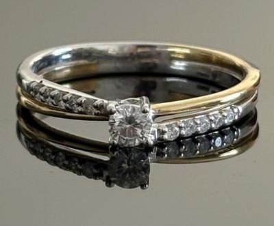 a close up of a diamond ring on a reflective surface