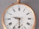 a gold pocket watch with roman numerals on it