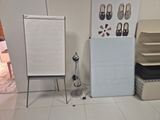 a picture of a room with a white board and a white chair