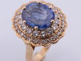 un gros plan d'une bague sertie d'un saphir bleu et de diamants blancs