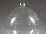 a clear glass bottle with a small amount of water in it