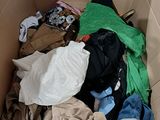 a cardboard box filled with clothes and clothes on the floor