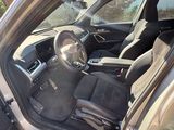 the interior of a car with the door open and the driver ' s seat down