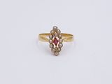 a close up of a gold ring with a red stone in the center