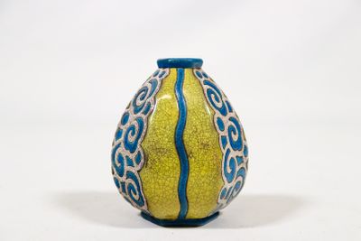 un vase jaune et bleu posé sur une surface blanche