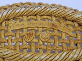 a close up of a yellow wicker chair with a plaque on it