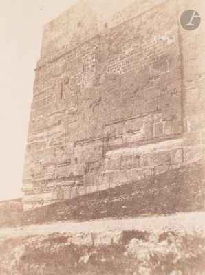 an old photo of a stone wall with a clock on it