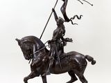 bronze statue of a man on a horse holding a flag