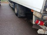 two trucks that are parked side by side on the street