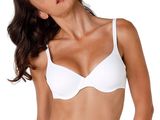 La femme en bikini blanc prend la pose devant l'appareil photo.
