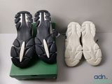 two pairs of black and white shoes sitting on top of a green box
