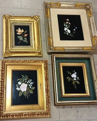 quatre tableaux représentant des fleurs, encadrés, sont exposés sur un sol carrelé
