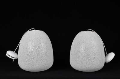 deux vases blancs posés l'un à côté de l'autre sur une surface noire
