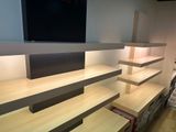 a tv on a wall above a shelf in a room