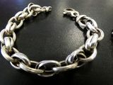 two pieces of silver and gold chain bracelets on a table