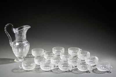 a lot of glasses and a pitcher sitting on a table