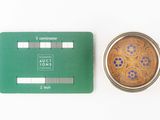 a green card next to a silver coin on a white surface