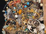 une valise noire remplie de nombreux bijoux, posée sur une table