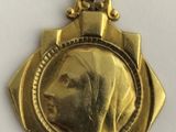 a close up of a gold medal with a woman ' s face on it