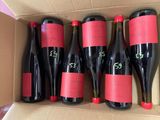 six bottles of red wine in a cardboard box on a table