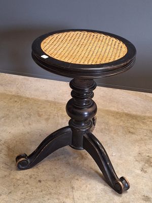 une table noire avec un plateau en osier et un piètement noir