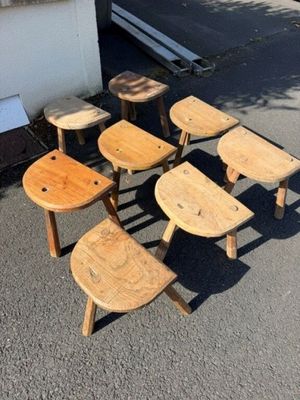 six tabourets en bois posés au milieu d'un parking
