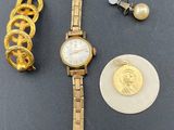 a gold watch and a gold bracelet on a table