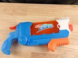 a blue and orange water gun on a wooden table