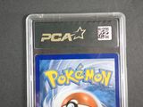 the pokemon card is in a plastic holder on a table